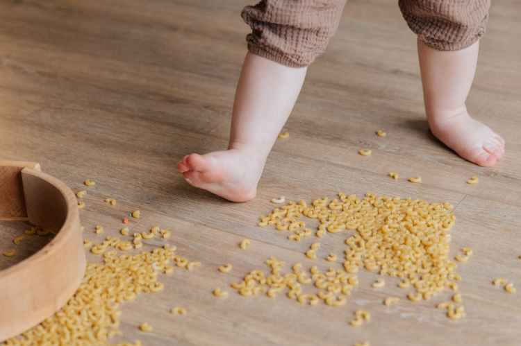 child stepping on macaroni
